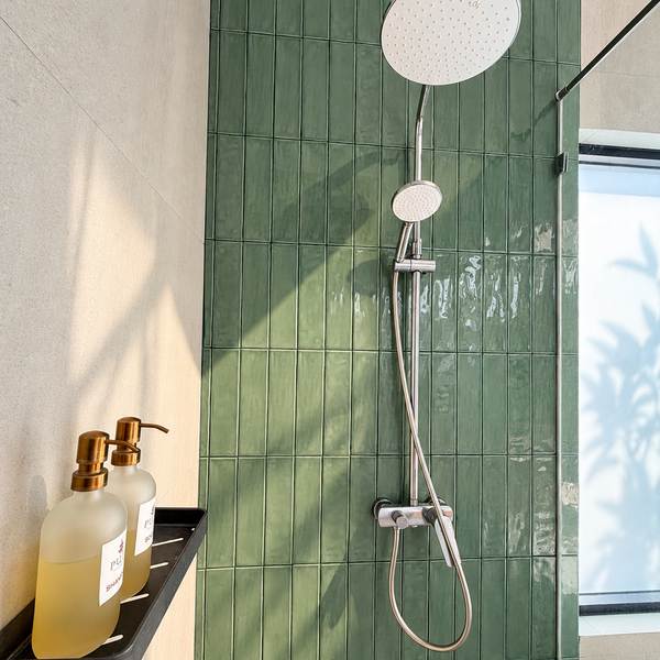 Rain shower against green stacked tile